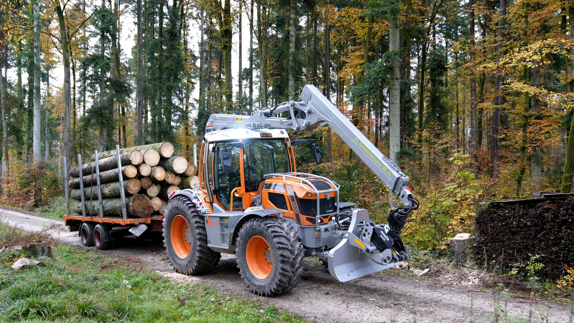 Pfanzelt Pm Trac on a forest track with a loaded forwarding trailer