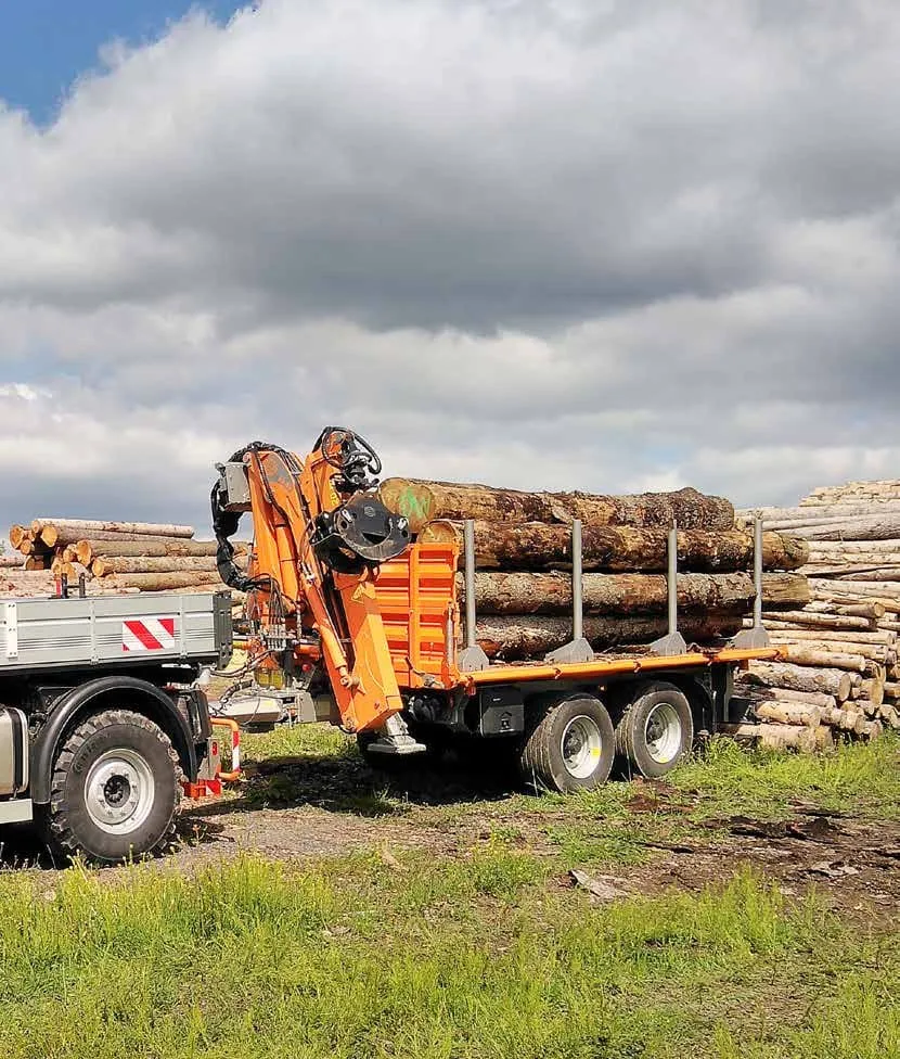 Schlang &amp; Reichart crane trailer loaded with timber behind a Mercedes-Benz Unimog