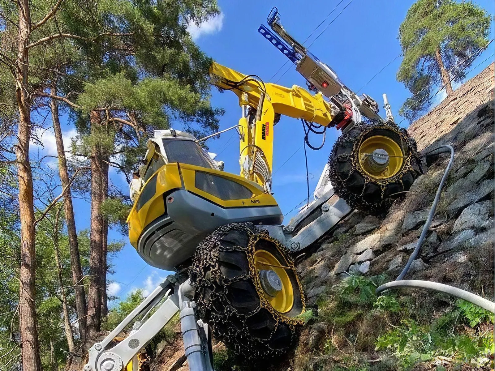 A Menzi Muck walking excavator climbing a stone wall on its wheel legs, seen from below against the trees and sky